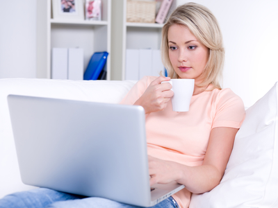 Woman with cup of coffee and laptop